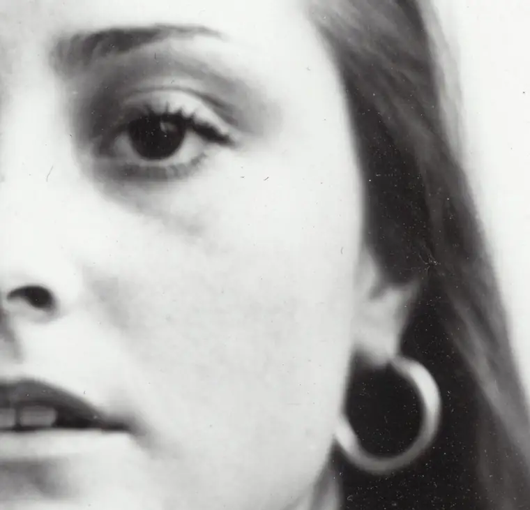 Primer plano en blanco y negro del rostro de Ángela Palacios: medio rostro llena el encuadre, la mirada fuera de cuadro y un aro grande en la oreja.